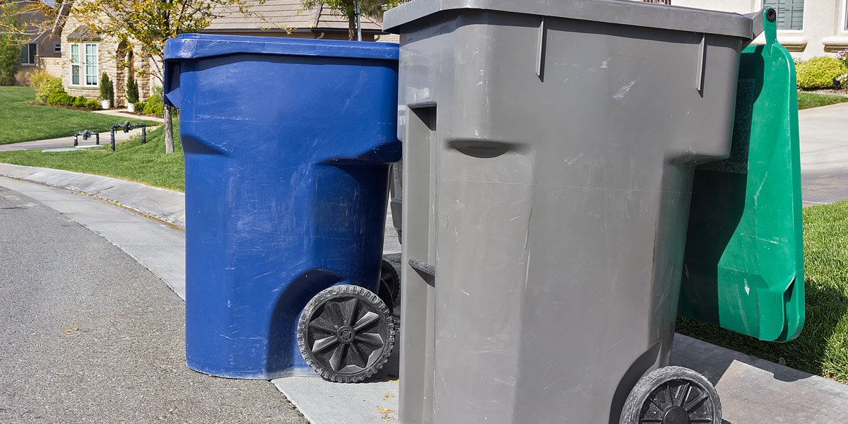 Modern garbage bin at a sidewalk.